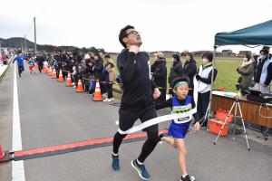 親子の部1位がお父さんがガッツポーズでゴールする写真