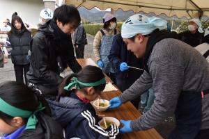 白川小PTA及び白川小サポートクラブが豚汁を渡す写真